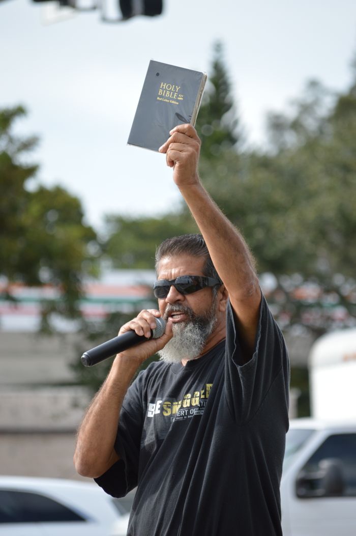 The Art of Drawing Readers In: Your attractive post title goes here Man with microphone and Bible speaking passionately outdoors.