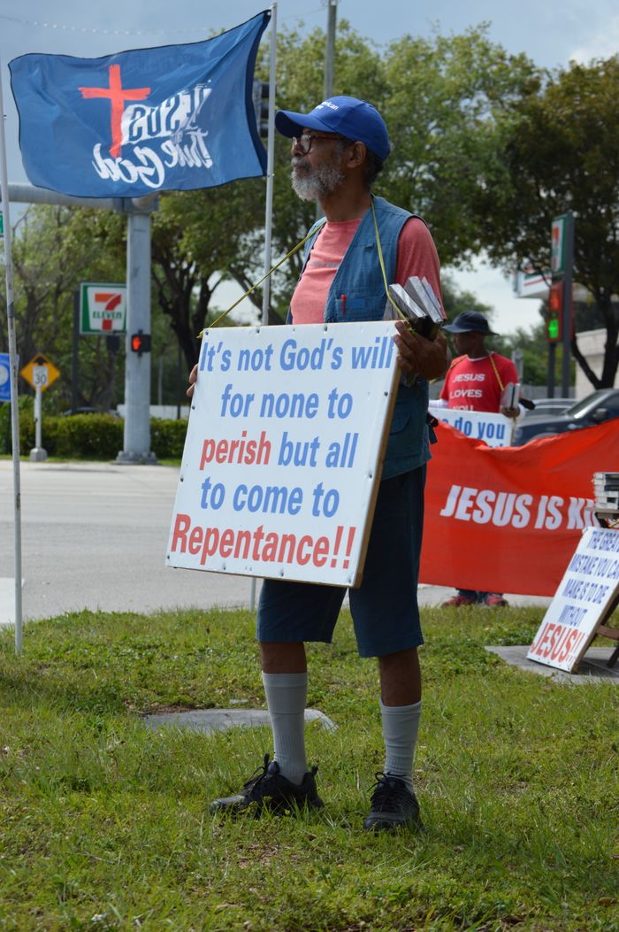 About An elderly man preaches repentance holding a sign on a street corner in West Palm Beach.