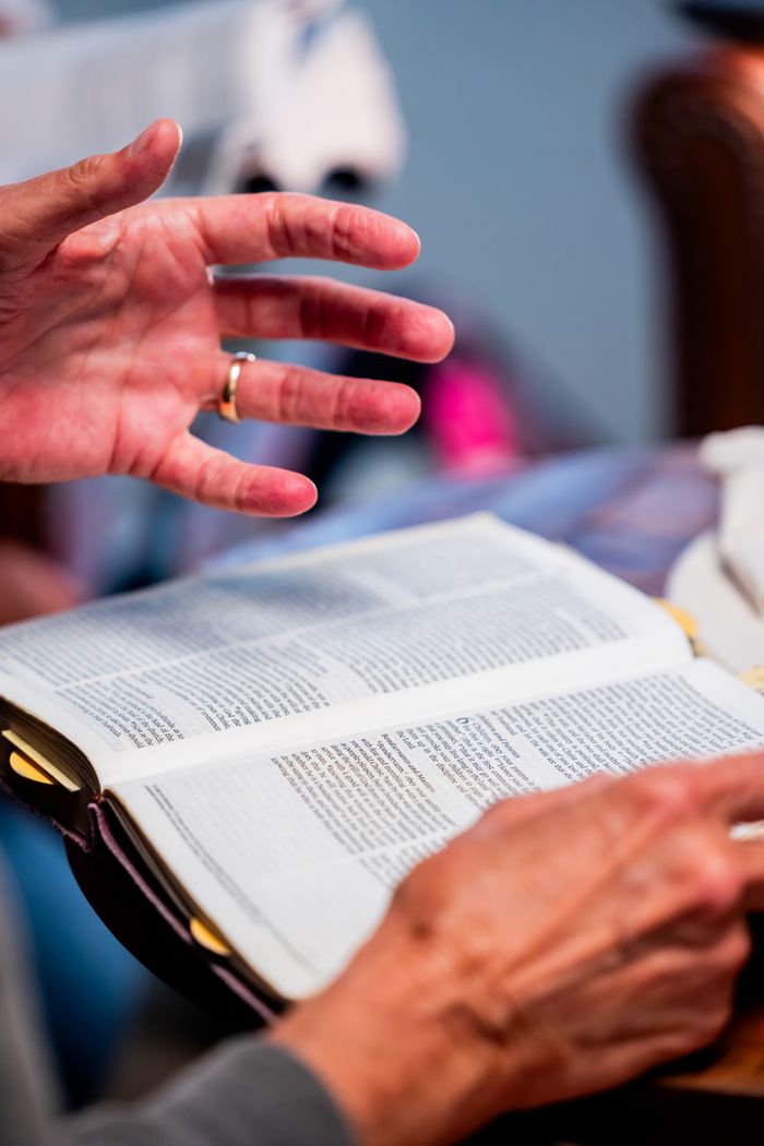 Mastering the First Impression: Your intriguing post title goes here Close-up of hands engaged in Bible study at an indoor setting, promoting spiritual discussion.